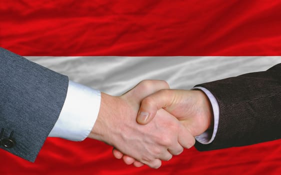 businessmen handshake after good deal in front of austria flag