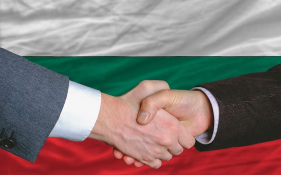 businessmen handshake after good deal in front of bulgaria flag
