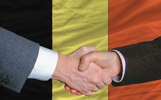 businessmen handshakeafter good deal in front of belgium flag