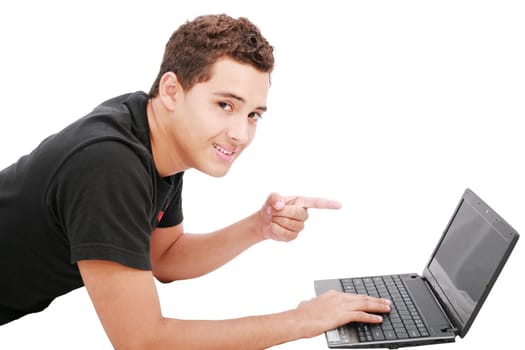 Young student is lying on the floor and looks  his laptop. Isolated on white.