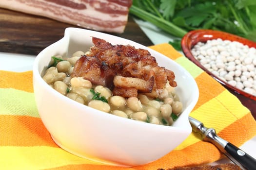 a bowl of white beans and fried bacon