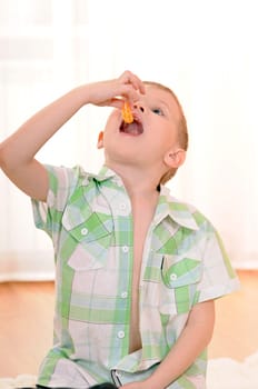 child sitting on the floor and eats an orange