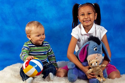 two children playing with toys against the blue mosaic background