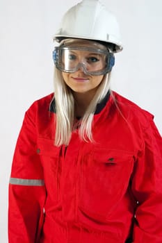 young woman builder in white helmet holding driller