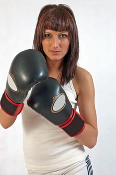 young beautiful woman in boxing gloves on the white background