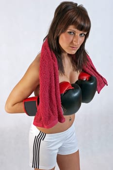 young beautiful woman in boxing gloves on the white background