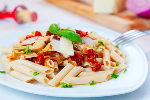 Closeup image of a pasta dish with sundried tomatoes and caramelized onions