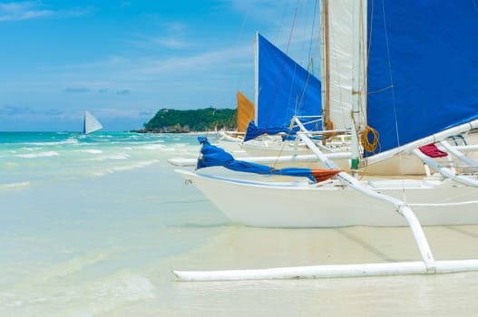traditional paraw sailing boats on white beach on boracay island, Philippines
