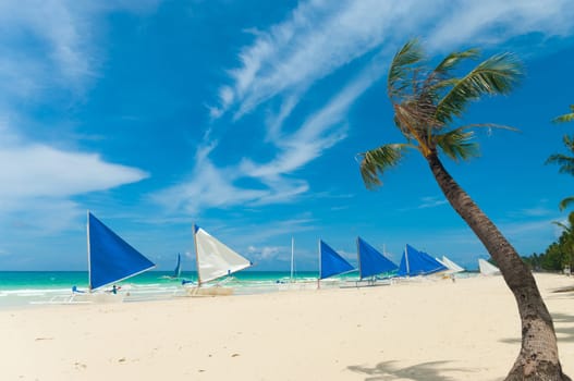 traditional paraw sailing boats on white beach on boracay island, philippines