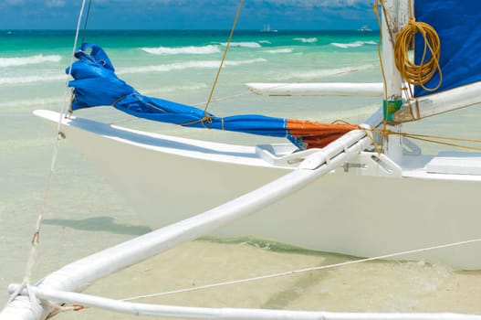 traditional paraw sailing boat on white beach on boracay island, Philippines