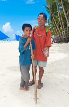 BORACAY ISLAND, PHILIPPINES - SEPTEMBER 05: Blind man with his son begging for money on September 05, 2011 on Boracay , Philippines. With no social securities this country is one of the poorest of south-east asia with over one million people living on the