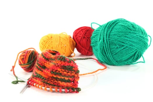 some colorful balls of wool with a knitting sample