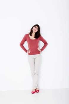 Beautiful woman standing with red shoes. Studio shot.