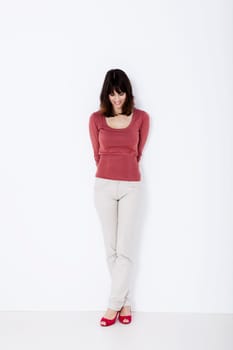 Beautiful woman standing and looking down. Studio shot.
