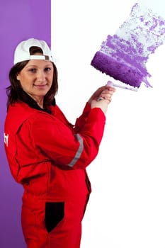 Girl painting the wall with paint