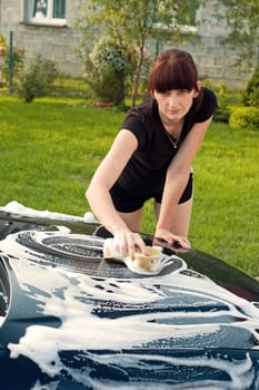 Adult cleaning her car outside