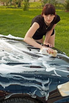 Adult cleaning her car outside