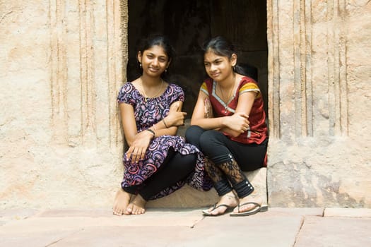 Two girls in happy disposition sitting on a doorstep