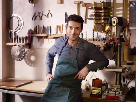 Portrait of adult italian man at work as craftsman in shop with tools in background