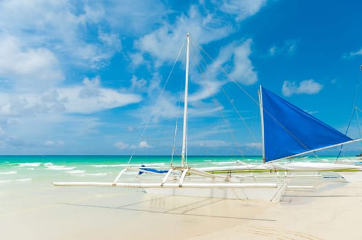traditional paraw sailing boats on white beach on boracay island, Philippines