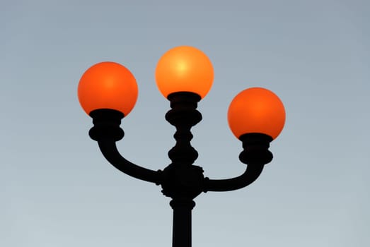 lamppost with three balls of orange light