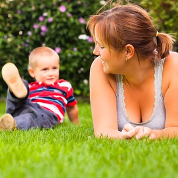 Happy woman with little boy enjoy summer day in the garden.