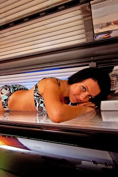Beautiful young woman tanning in solarium