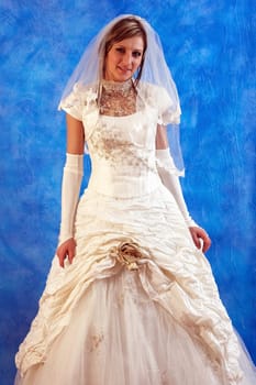 Young beautiful bride in a white wedding dress on the blue mosaic background