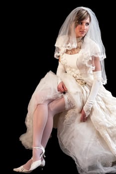 Young beautiful bride in a white wedding dress on the black background
