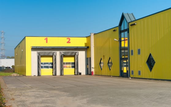 yellow industrial warehouse with numbered loading docks