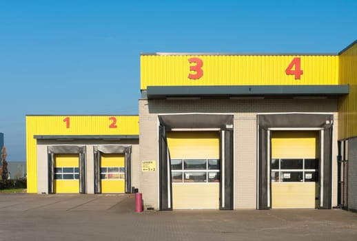 yellow industrial warehouse with numbered loading docks