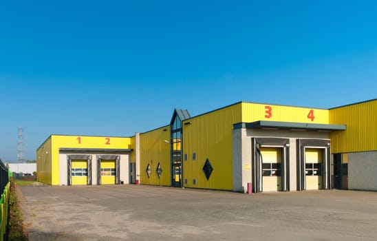 yellow industrial warehouse with numbered loading docks