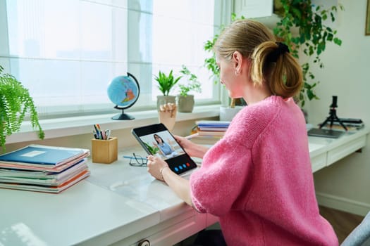 Teenage girl high school student having video conference on digital tablet at home, remote lesson learning language online lecture educational webinar. E-education knowledge adolescence technology