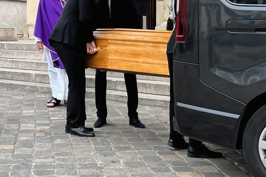 Funeral service loading the coffin into the hearse