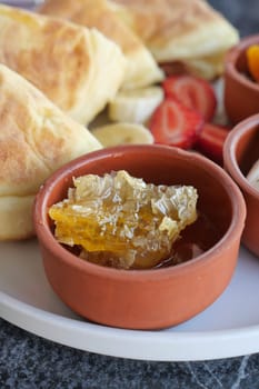 close up of fresh honey with comp in a jar .