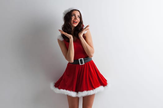 Pretty Pin-up style Santa girl in red hat on white background