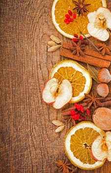 dried oranges with cinnamon and anise, on wooden background