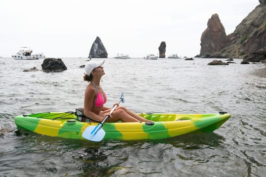 Kayaking. Travel adventure kayak on the tropical sea on a sunny day. Woman rowing a canoe.