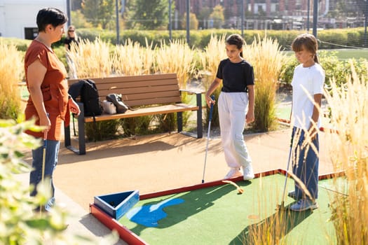 Kids playing golf inside playground artificial grass activity game for children . High quality photo