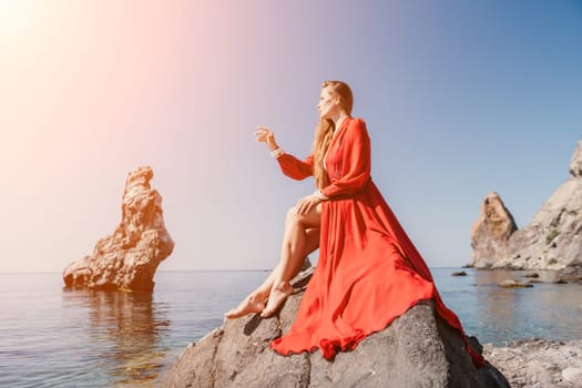 Woman travel sea. Happy tourist taking picture outdoors for memories. Woman traveler looks at the edge of the cliff on the sea bay of mountains, sharing travel adventure journey.