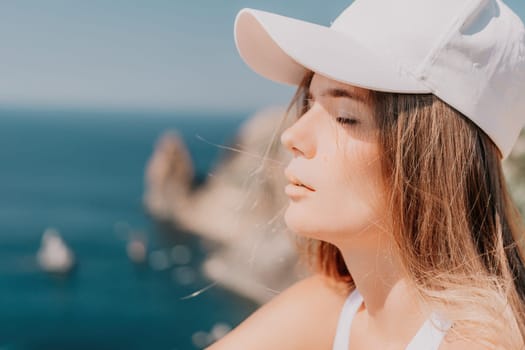 Woman travel sea. Young Happy woman in a long red dress posing on a beach near the sea on background of volcanic rocks, like in Iceland, sharing travel adventure journey