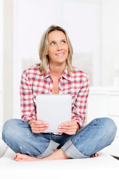 beautiful blond woman on sofa with tablet