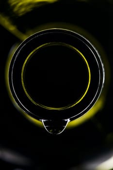 green wine bottle with drops shiny against black background