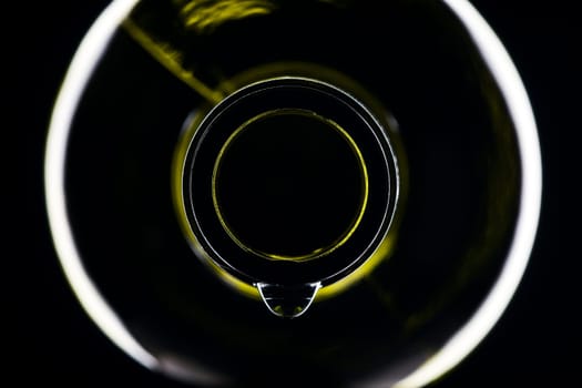 green wine bottle with drops shiny against black background