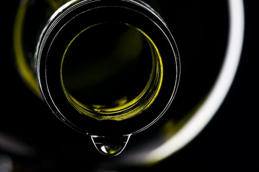 green wine bottle with drops shiny against black background