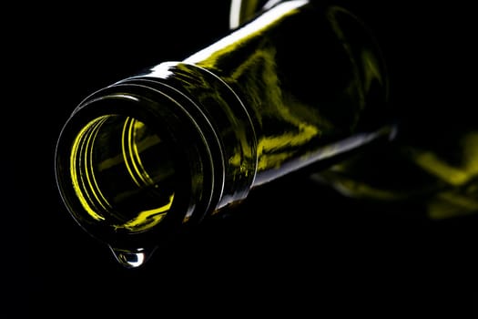 green wine bottle with drops shiny against black background