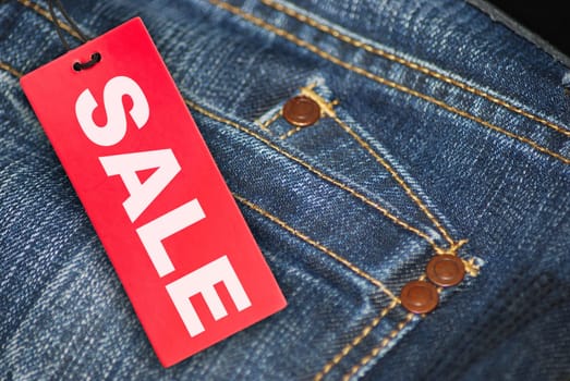 Red Sale Sign With Jeans in Background