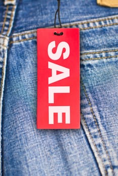 Red Sale Sign With Jeans in Background