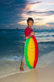 philippine boy posing for the camera with a colorful wakeboard