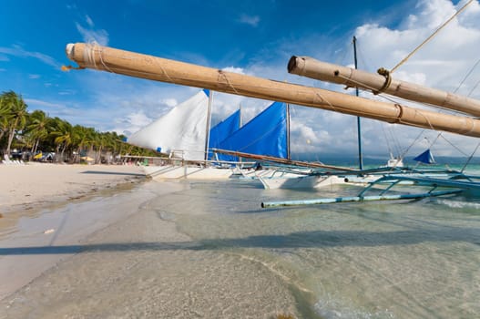 traditional Philippine paraw sailing boats on the famous white beach on Boracay